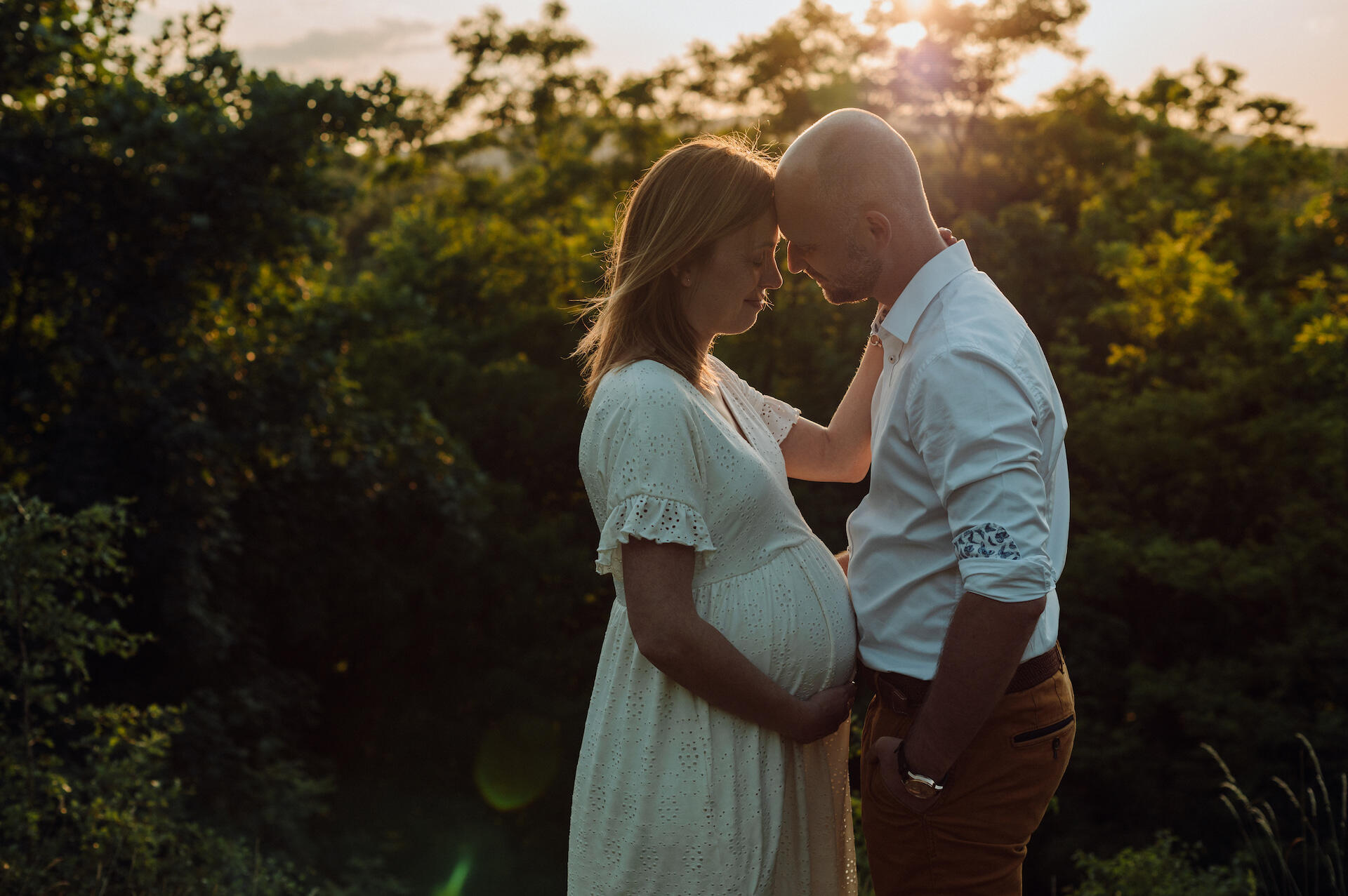 Rodzinna sesja plenerowa w Krakowie o zachodzie słońca – naturalne ujęcia rodziców w złotym świetle, fotograf Anna Janowska.